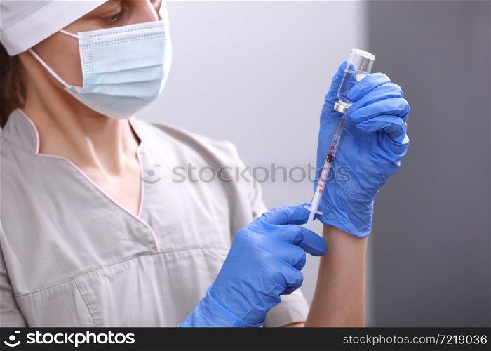 Biological hazard. Epidemic of the Chinese coronavirus. Doctor, nurse, scientist in a protective suit and mask holds an injection syringe and vaccine. Vaccine from, flu, coronavirus, ebola, TB. Biological hazard. Epidemic of the Chinese coronavirus. Doctor, nurse, scientist in a protective suit and mask holds an injection syringe and vaccine. Vaccine from, flu, coronavirus, ebola, TB.