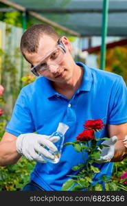 Biologist professional with a test tube takes a sample of flowers