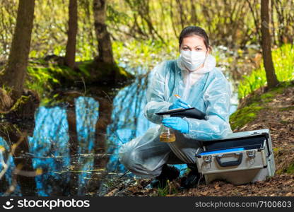 biologist takes water from a forest river to study the composition in the laboratory