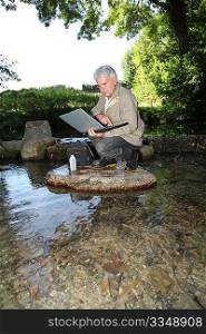 Biologist testing quality of stream water