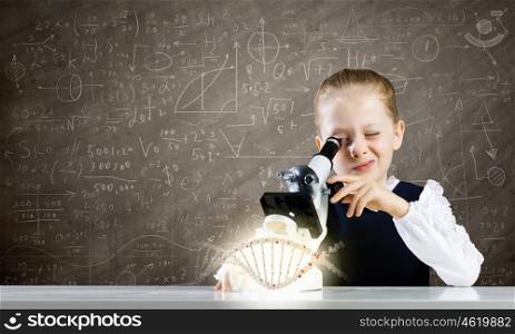Biology lesson. Cute school girl examining dna molecule with microscope