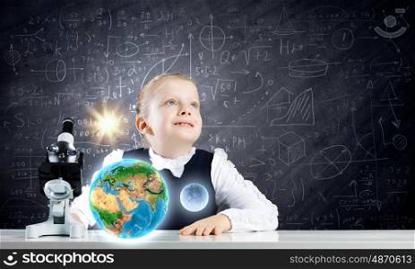 Biology lesson. Cute schoolgirl at school lesson using microscope. Elements of this image are furnished by NASA