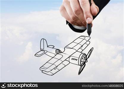 Biplane sketch. Person hand drawing old airplane on sky background