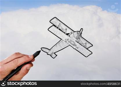 Biplane sketch. Person hand drawing old airplane on sky background