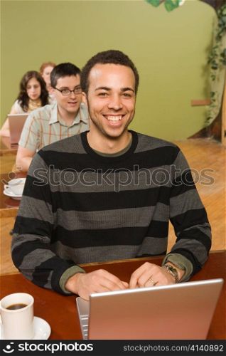 Biracial Man at Head of Row of Laptop Users