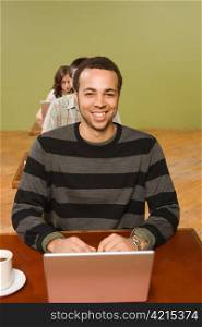 Biracial Man at Head of Row of Laptop Users