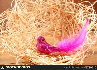 bird in straw nest with pink feathers and glitter body