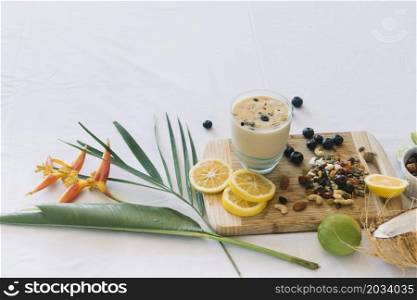 bird paradise flower smoothie with dryfruits citrus fruits white background