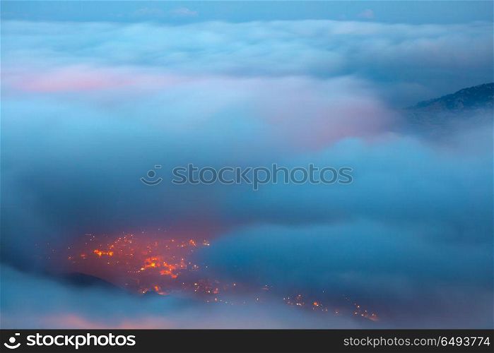 Bird&rsquo;s eye view on Faraya mountain, Lebanon, amazing view from above through clouds on mountainous city, glowing lights from the homes windows at night. Bird&rsquo;s eye view on Faraya mountain