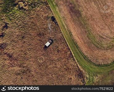 Bird view of old abandoned and rusty vehicles in the autumn field