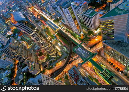 Birds eye view of a modern building at night. Traffic in the business district The Skytrain station Chong Nonsi. Modern building night view