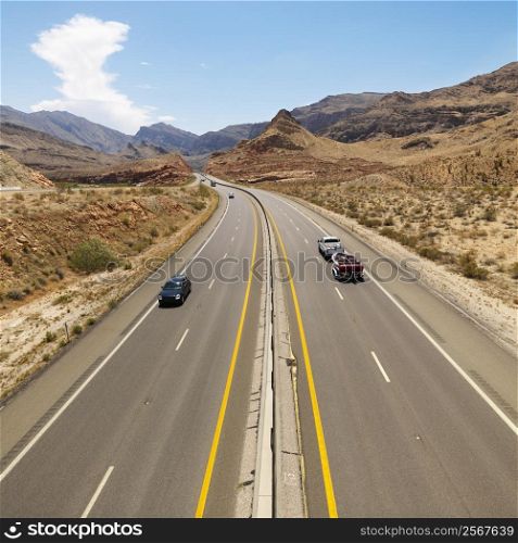 Birds eye view of automobiles on rural desert highway.