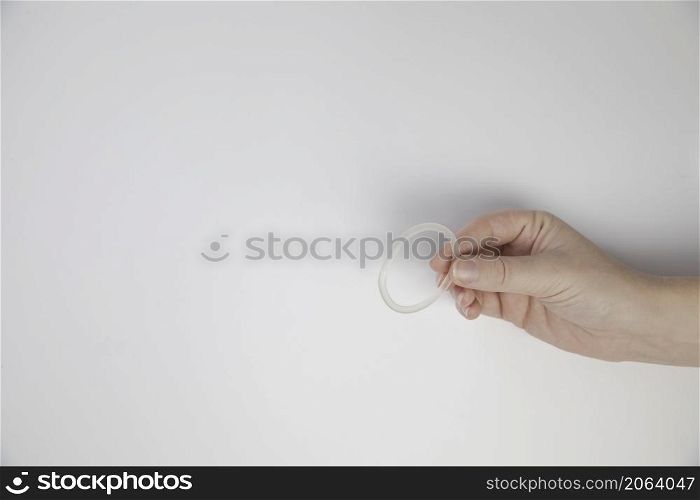 Birth control ring in a womans hand isolated on white background, vaginal ring for contraceptive use close-up copy space. Birth control ring in a womans hand isolated on white background, vaginal ring for contraceptive use close-up