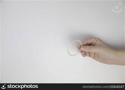 Birth control ring in a womans hand isolated on white background, vaginal ring for contraceptive use close-up copy space. Birth control ring in a womans hand isolated on white background, vaginal ring for contraceptive use close-up
