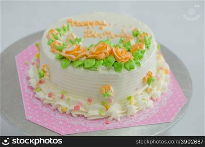Birthday cake. Birthday cake with orange flowers and green leaves