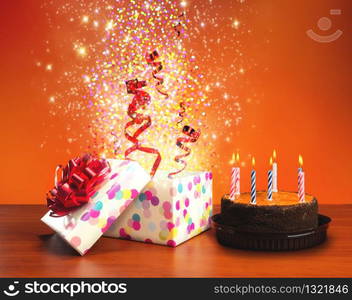 Birthday cake with candles and present-boxes on the table. Birthday cake and presents