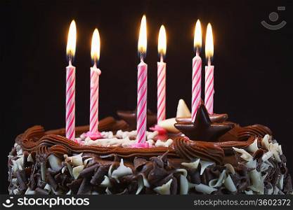 Birthday cake with lit candles, close-up