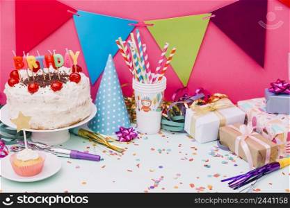 birthday cake with party accessories confetti blue background