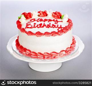 Birthday cake with white and red icing on plate