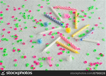 Birthday candles displayed on a white background littered with green and pink confetti