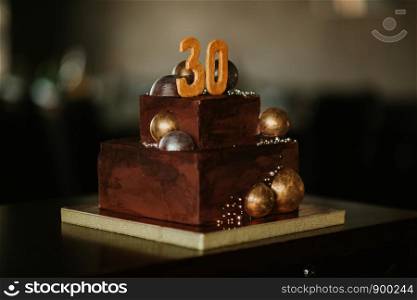 birthday chocolate cake with a number thirty. decorated with golden chocolate balls.. birthday chocolate cake with a number thirty. decorated with golden chocolate balls. Happy birthday