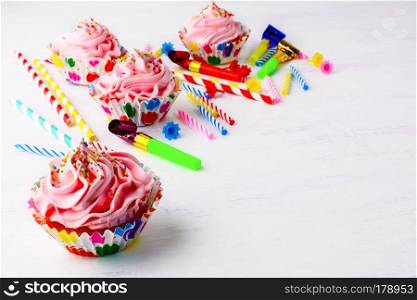 Birthday party background with decorated pink cupcakes  and candles. Homemade cupcakes served for party. Birthday card background. Copy space.
