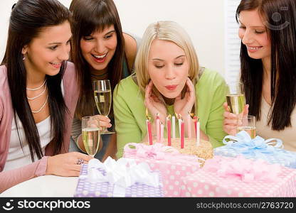 Birthday party - woman blowing candle on cake, champagne, presents