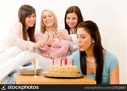 Birthday party - woman blowing candle on cake, champagne, toast