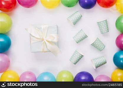 birthday present disposable cup inside balloons border white background