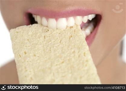 Biscuit in woman teeth and mouth having a healthy snack