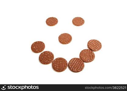 Biscuits arranged in shape of smiley face over white background