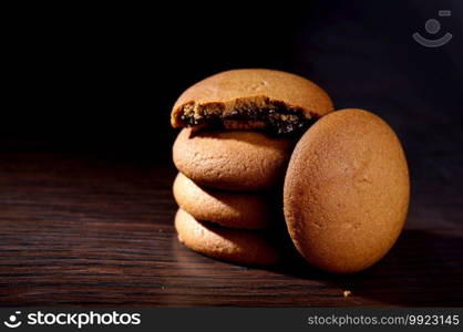 Biscuits filled with chocolate cream. Chocolate cream cookies. brown chocolate biscuits with cream filling on black background.