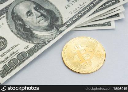 Bitcoin coin and a pile of US dollar banknotes. Blockchain money versus fiat money concept