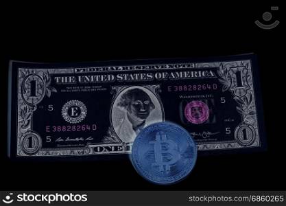 Bitcoin coin on one U.S. dollar banknote on black