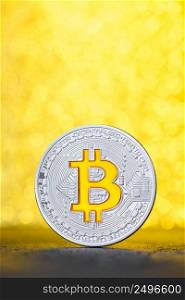 Bitcoin coin with golden bitcoin symbol on black table with gold glitter bokeh background