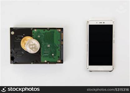 Bitcoin coin with HDD. Bitcoin coin on the HDD and phone on a white
