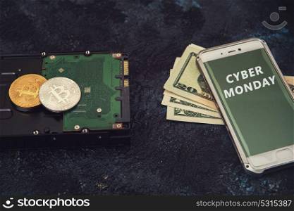 Bitcoin coins on the HDD and phone with Cyber Monday sign. Bitcoin coin with HDD