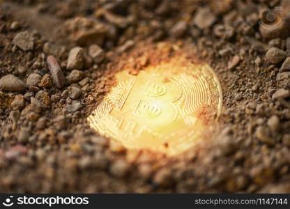 Bitcoin Golden on ground soil deep with light / Virtual cryptocurrency bitcoin mining concept