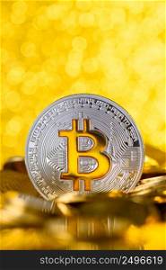 Bitcoin stands on pile of golden coins, big silver coin with gold Bit symbol, vertical with copy space