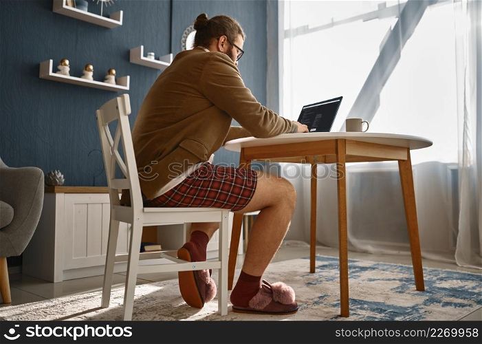 Bizarre guy geek working online from home office using laptop computer. Bizarre guy geek working online