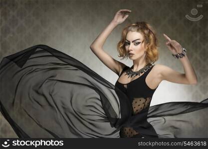 bizarre portrait of fashion sensual woman with gothic style, strong make-up and rock accessories posing with big veil flying skirt. Carnival look
