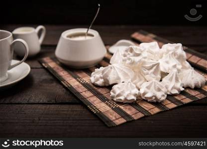 bizet on a brown wooden table with a cup of tea, sugar and milk