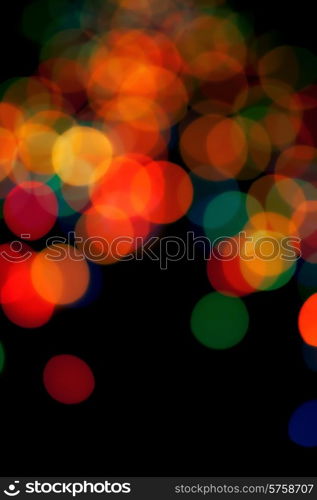 Black abstract background with colorful blurred lights