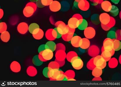 Black abstract background with colorful blurred lights