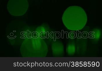 Black abstract background with green blurred particles