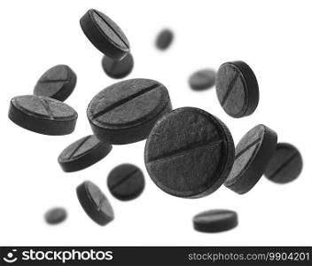 Black activated carbon tablets levitate on a white background.. Black activated carbon tablets levitate on a white background