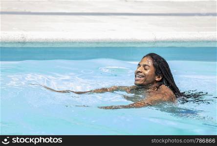black African-American with dreadlocks swimming in a pool