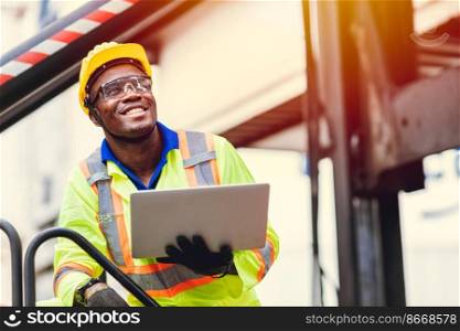 Black African happy worker working in logistic shipping with laptop computer control loading containers at port cargo. Import export shipping industry people.