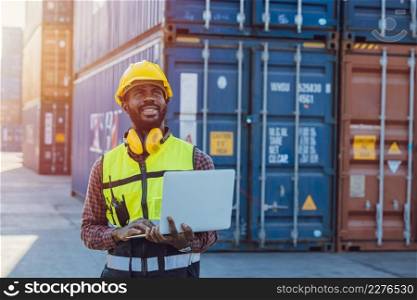 Black African staff workerworking in cargo shipping logistic port with laptop computer.