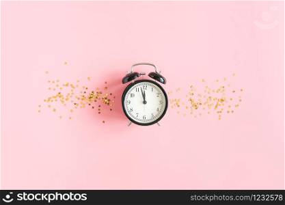 Black alarm clock and gold stars confetti on pink background. Concept Insomnia, sleep problems or sweet dreams and good night. Top view Flat lay Copy space.. Black alarm clock and gold stars confetti on pink background. Concept Insomnia, sleep problems or sweet dreams and good night. Top view Flat lay Copy space